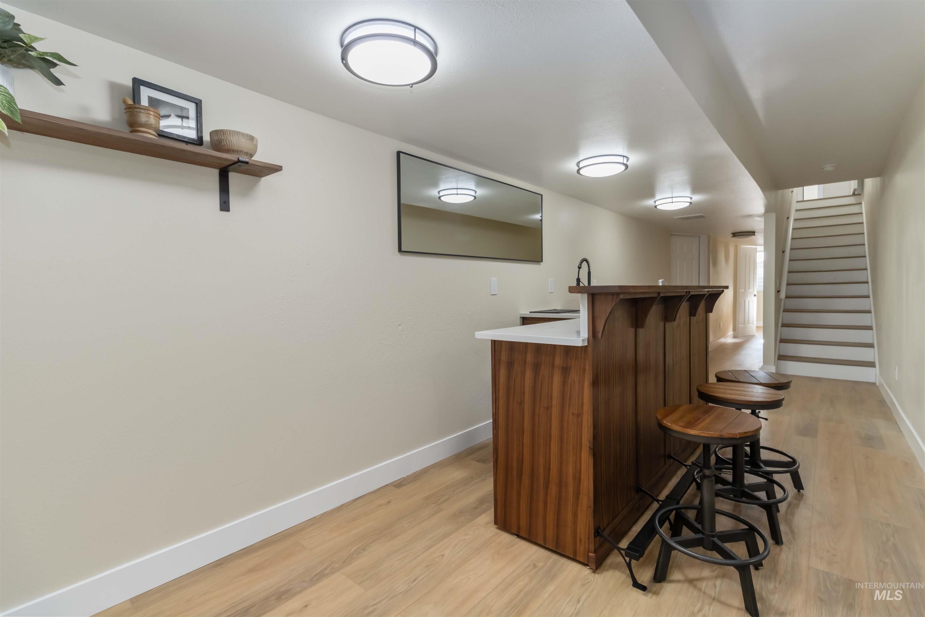 3201 Raintree Drive Nampa, ID 83686 - Photo 33 of 50 Indoor wet bar with light wood finished floors, stairway, open shelves, and light countertops