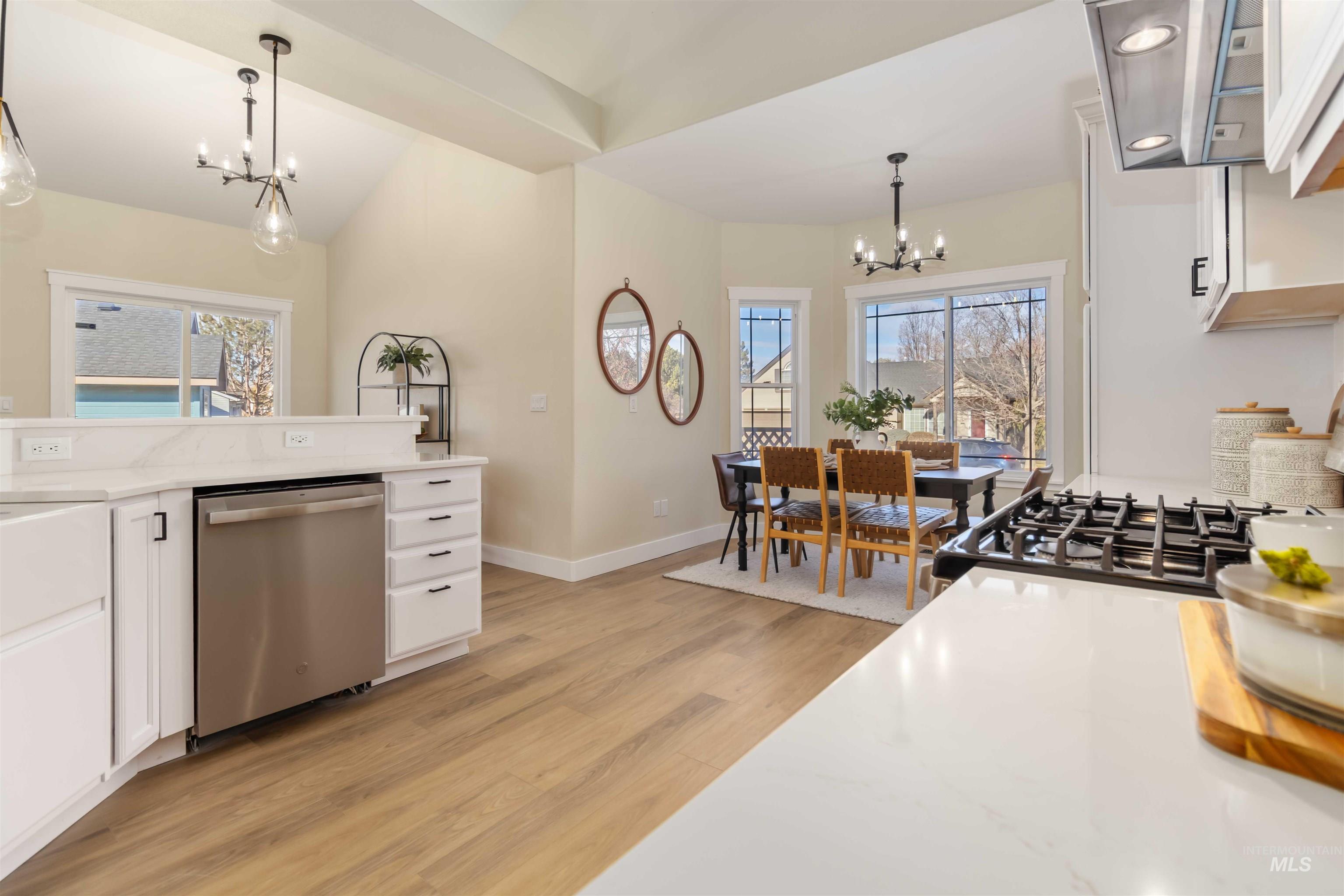 3201 Raintree Drive Nampa, ID 83686 - Photo 8 of 50 Kitchen with white cabinets, a chandelier, pendant lighting, dishwasher, and lofted ceiling