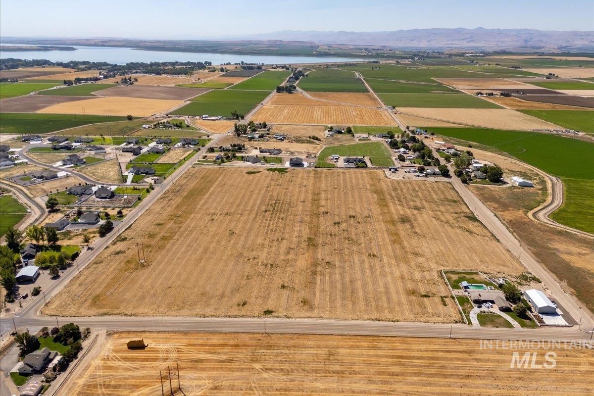 Aerial overview of property's location featuring a water and mountain view, rural landscape, and rows of crops