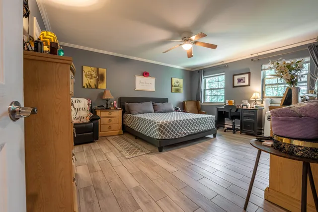 a bedroom with a bed and wooden floor
