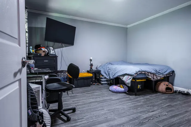 a bedroom with furniture and a flat screen tv