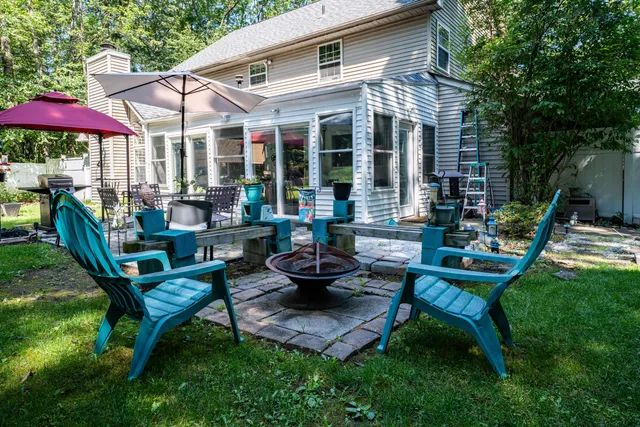 a view of a patio with couches table and chairs under an umbrella