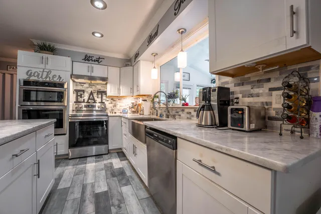 a kitchen with stainless steel appliances granite countertop a stove and cabinets