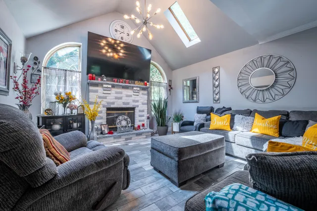 a living room with furniture a fireplace and a flat screen tv