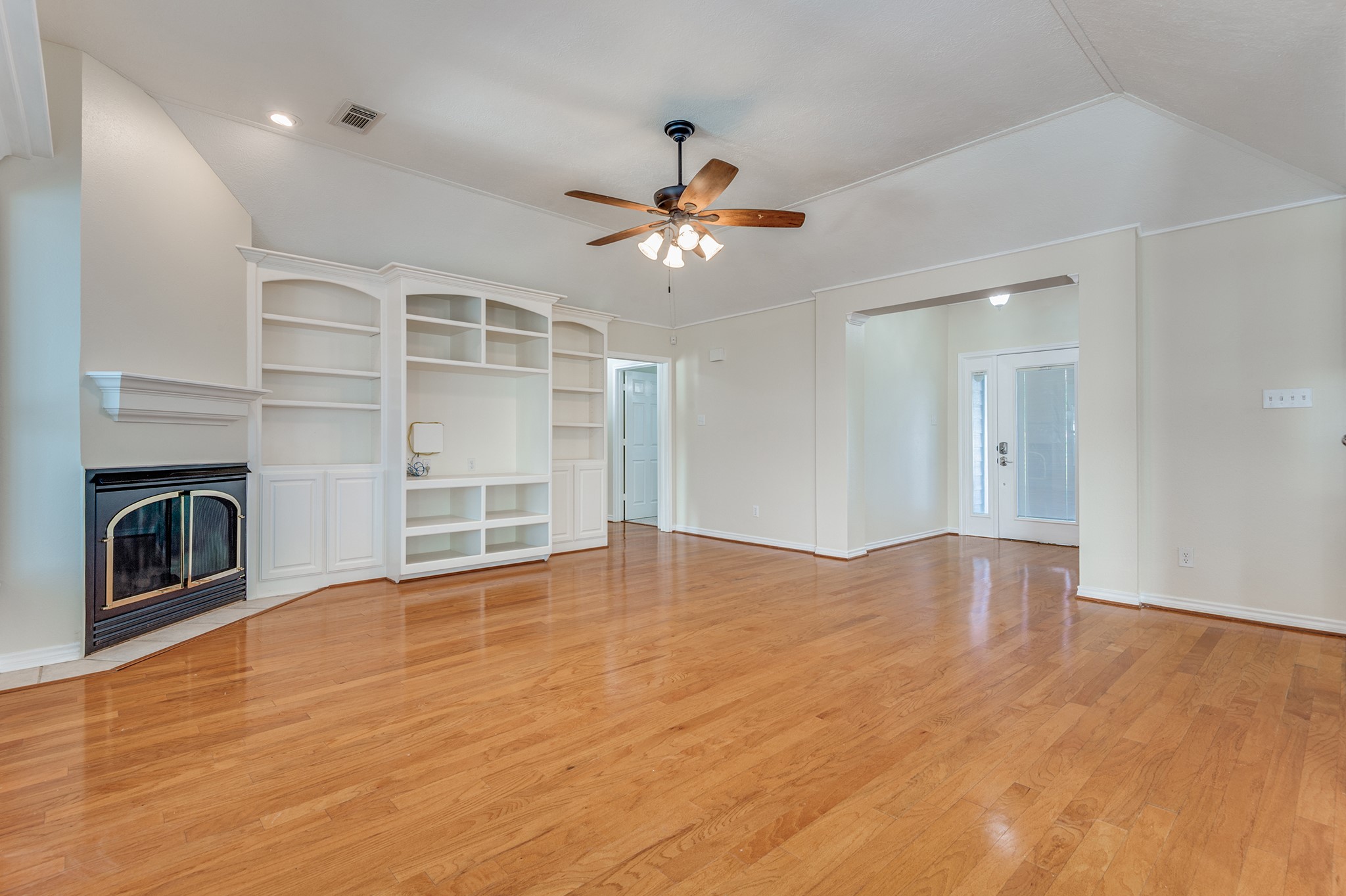 341 Sam Houston Loop Point Blank, TX 77364 - Photo 4 of 36 a view of an empty room with a fireplace and a chandelier fan