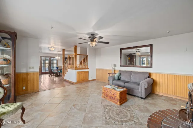 a living room with furniture and a ceiling fan