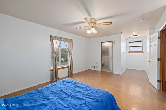 an empty room with windows and fan