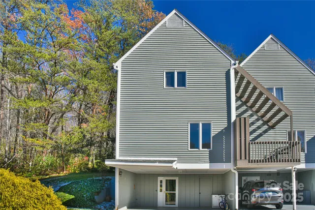 a view of a house with a yard and potted plants