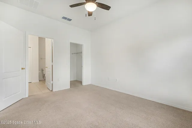 an empty room with a chandelier fan