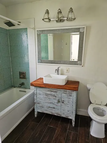 a kitchen with granite countertop a stove cabinets and wooden floor