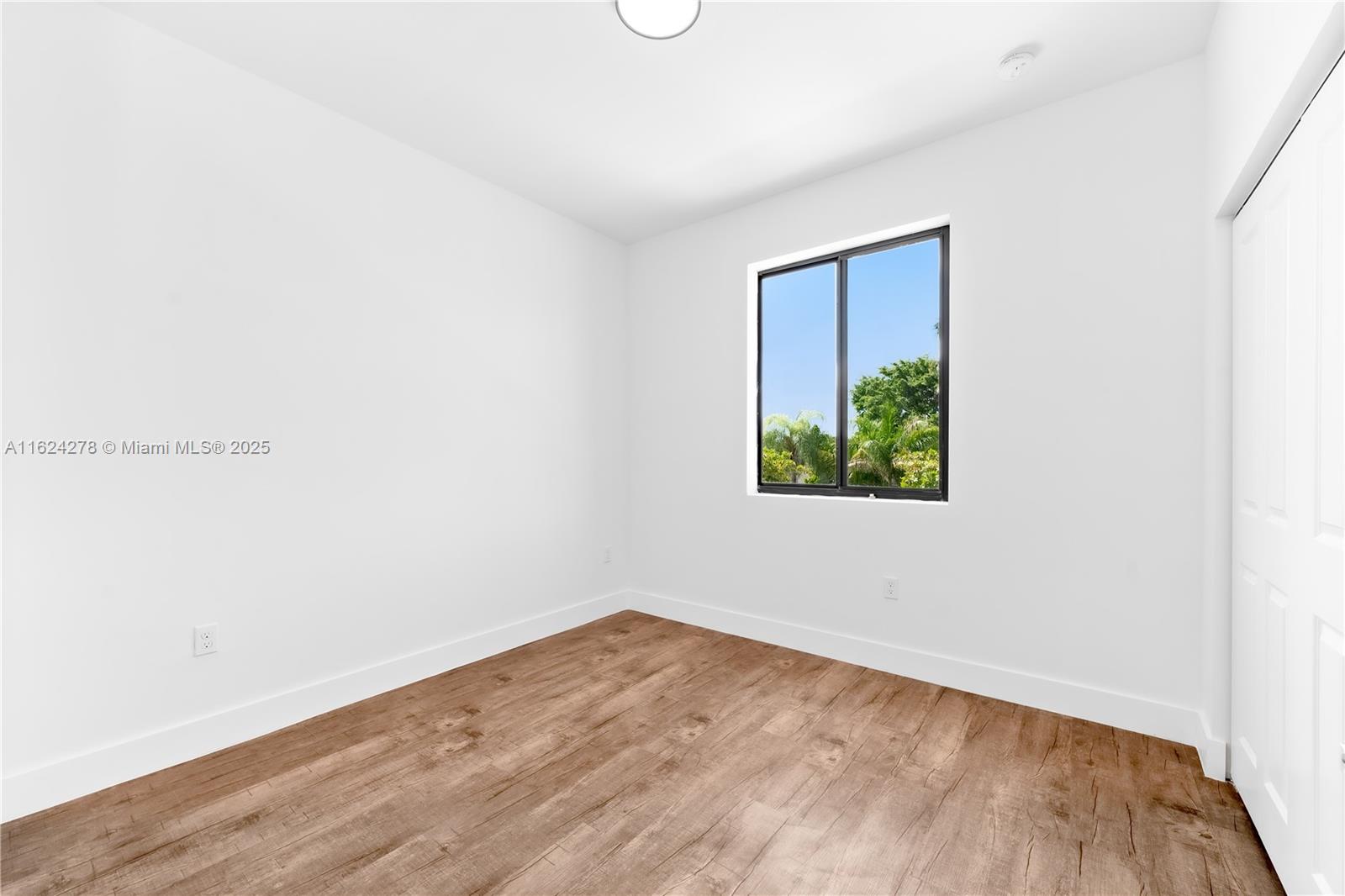 866 Southwest 1st Street Florida City, FL 33034 - Photo 18 of 52 a view of an empty room with wooden floor and window