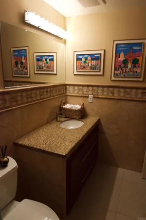 a bathroom with a granite countertop sink a toilet and a shower