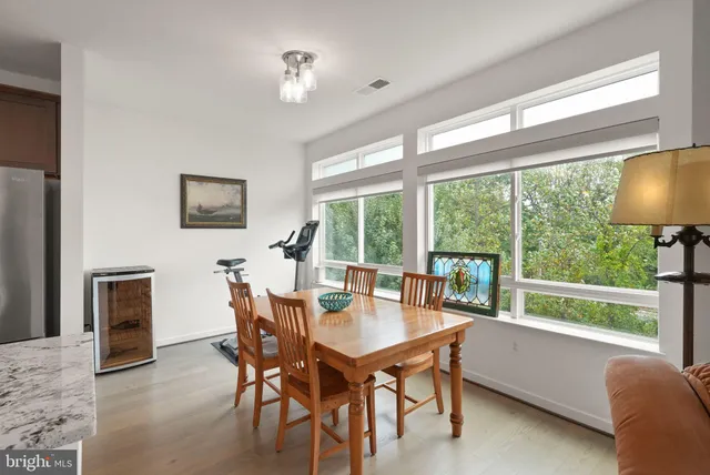 a dining room with furniture a flat screen tv and a large window