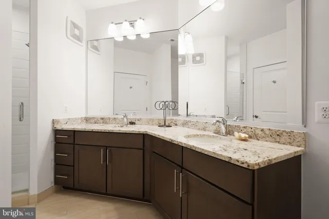 a bathroom with a granite countertop sink and a mirror