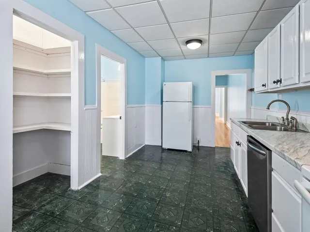 a kitchen with granite countertop a sink and a refrigerator