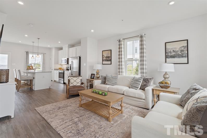 a living room with furniture wooden floor and a large window