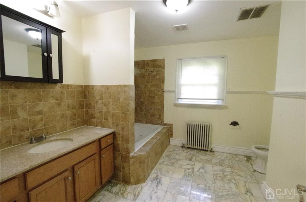 127 Blair Road Port Reading, NJ 07064 - Photo 8 of 17 a bathroom with a granite countertop sink a toilet and mirror
