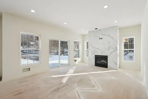a view of an empty room with a fireplace and a window