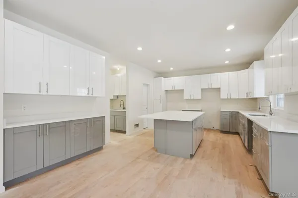 a large kitchen with kitchen island a sink a center island stainless steel appliances and a cabinets
