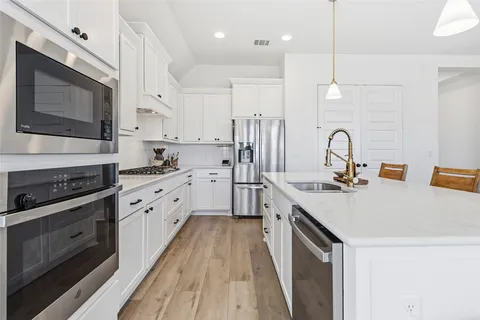 a kitchen with stainless steel appliances a stove sink and microwave