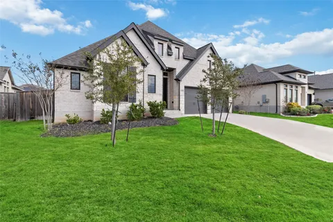 a view of a house with a yard and pathway