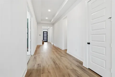 a view of a hallway with wooden floor