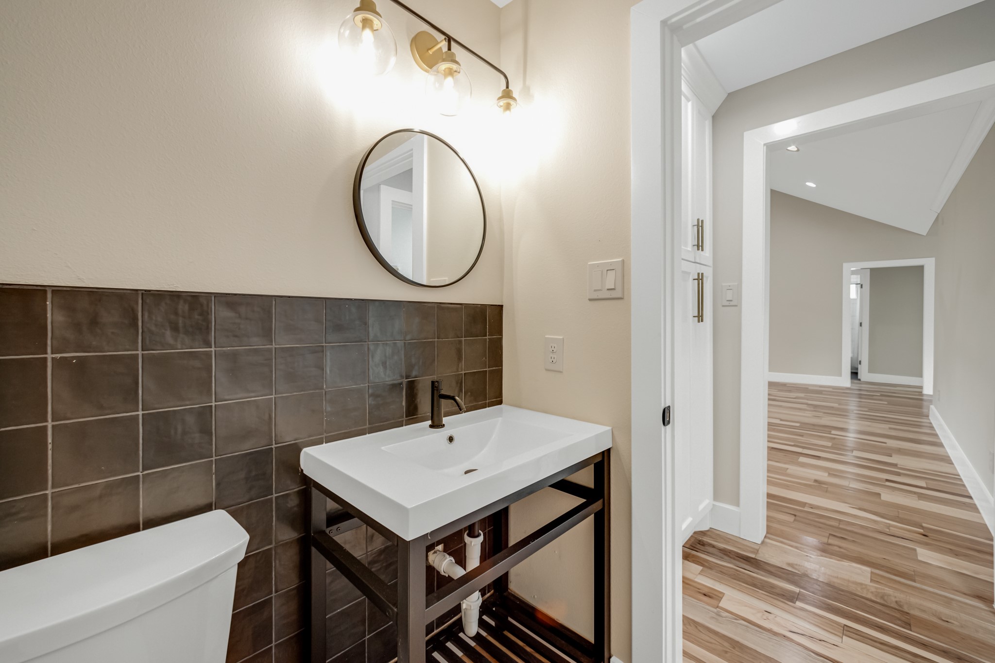 403 Moody Street Houston, TX 77009 - Photo 20 of 38 Half bath is convenient but not to close to living area and features a beautiful black tile wall and console sink