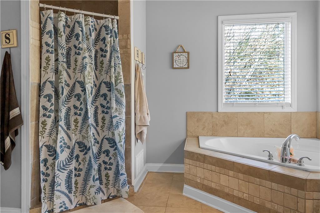 235 Brooks Road Pendergrass, GA 30567 - Photo 19 of 33 a bathroom with a bathtub and shower