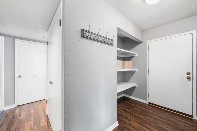 a kitchen with stainless steel appliances a stove a sink dishwasher a refrigerator white cabinets and wooden floor