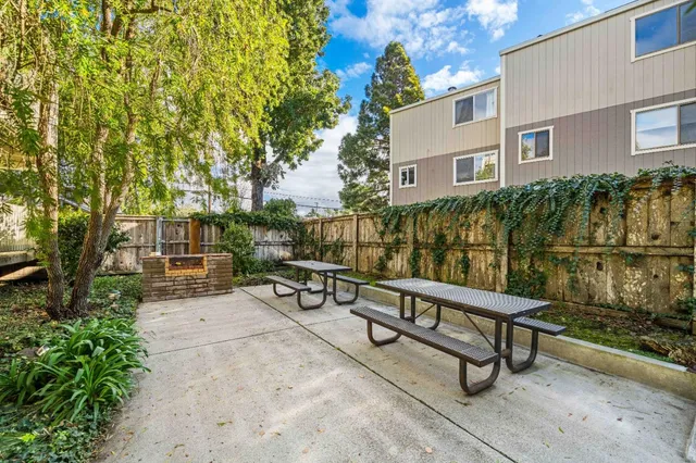 a view of a white building among the street and parked cars