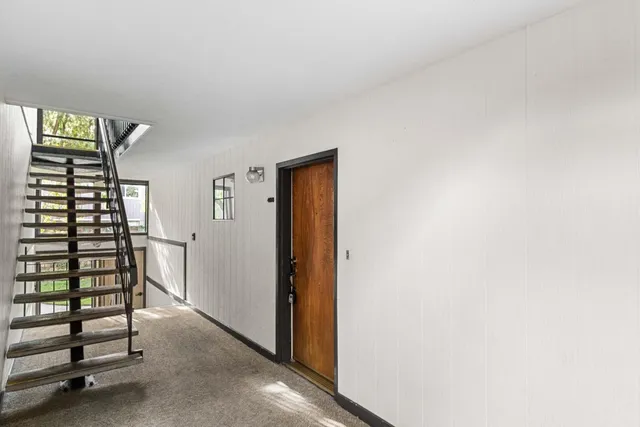 a view of a hallway with windows and stairs