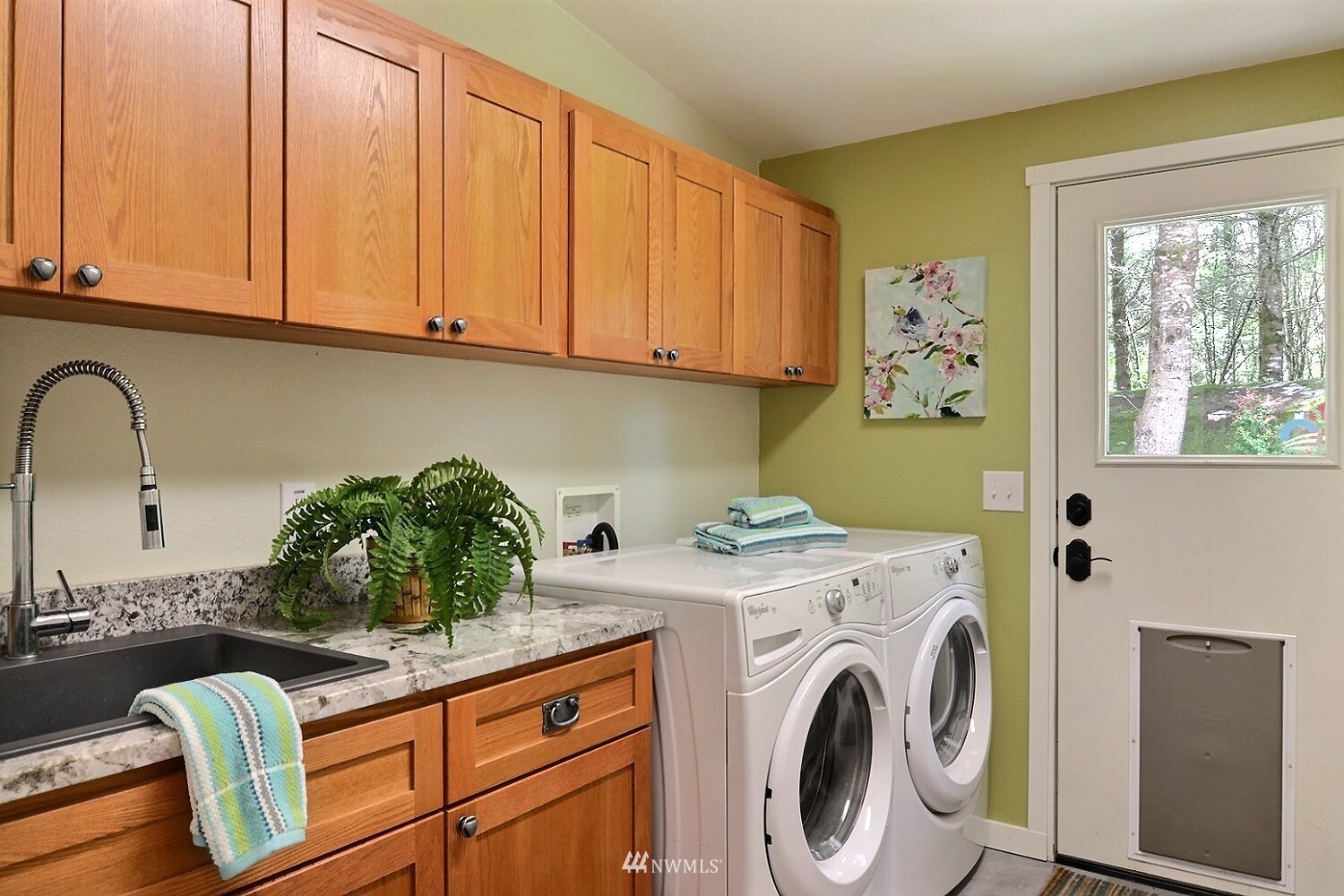 4704 Whiteman Road Southwest Longbranch, WA 98351 - Photo 20 of 40 a view of washer and dryer with kitchen in the background