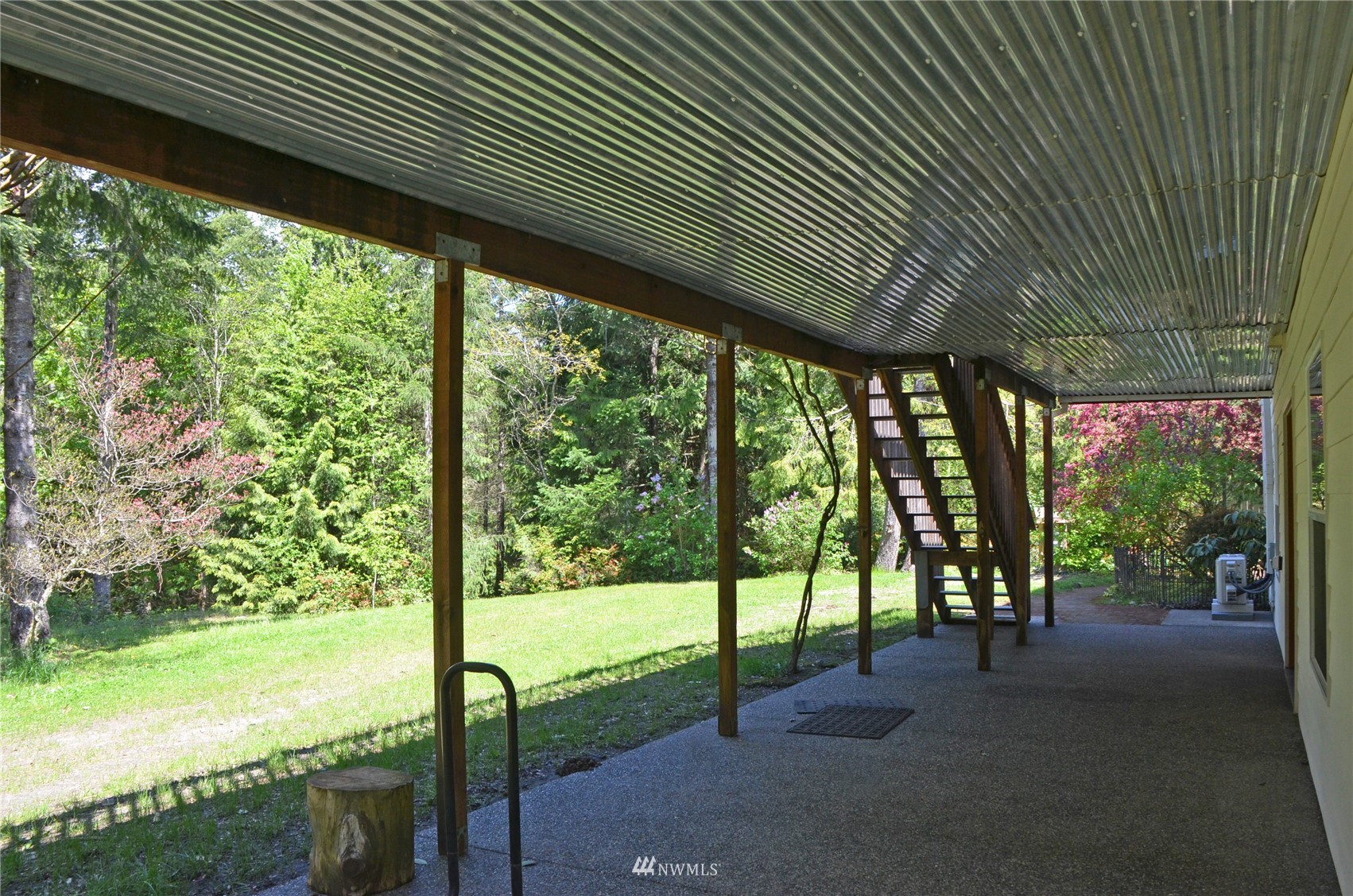 4704 Whiteman Road Southwest Longbranch, WA 98351 - Photo 27 of 40 a view of a patio with table and chairs and floor to ceiling window next to a yard