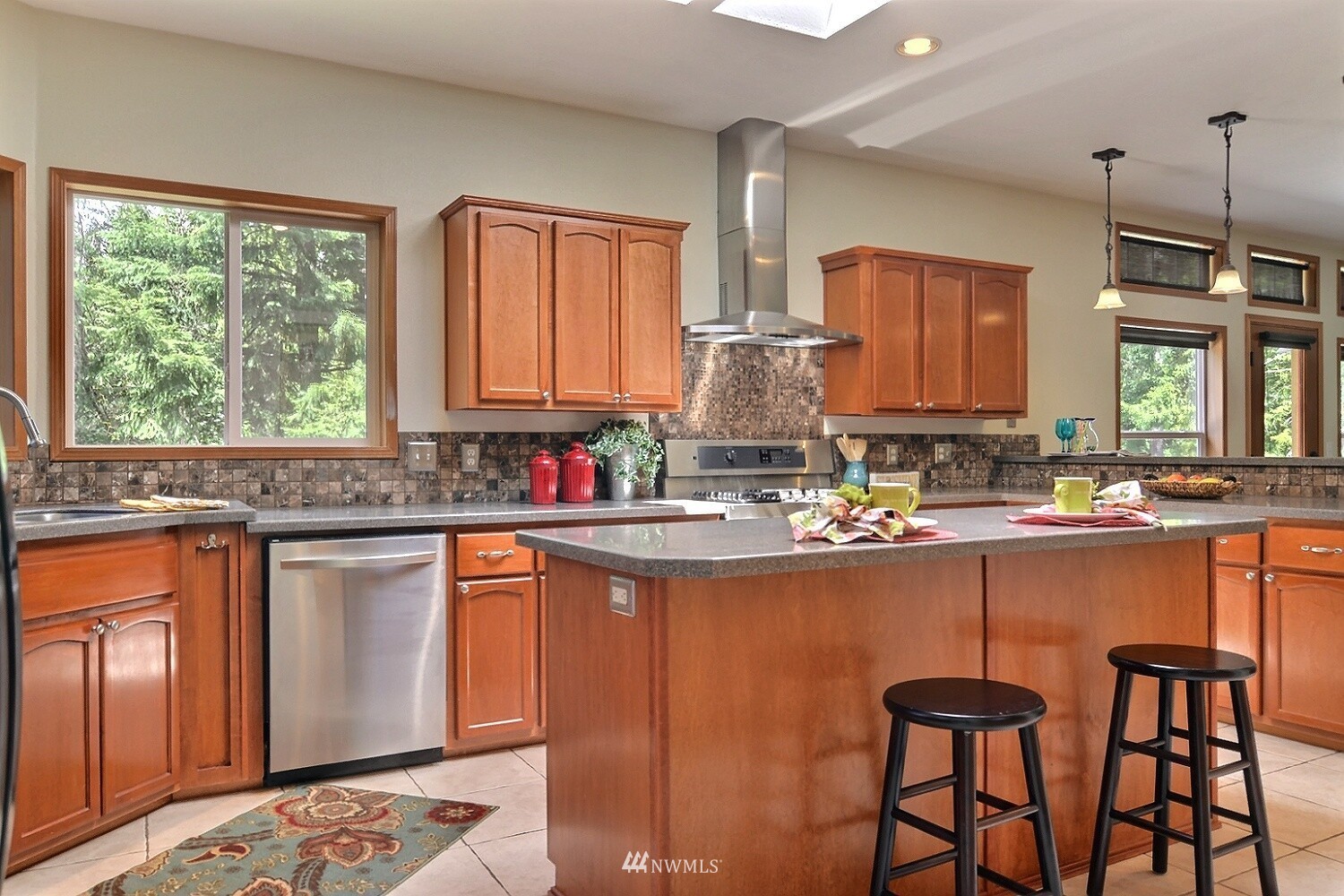 4704 Whiteman Road Southwest Longbranch, WA 98351 - Photo 9 of 40 a kitchen with stainless steel appliances granite countertop a stove a sink and a refrigerator