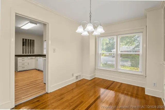 a view of a room with wooden floor and chandelier