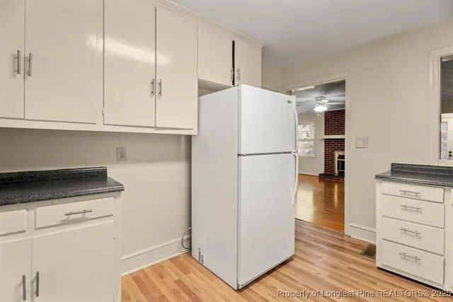 a kitchen with a refrigerator and a stove top oven