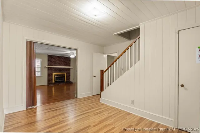 a view of empty room with wooden floor and stairs