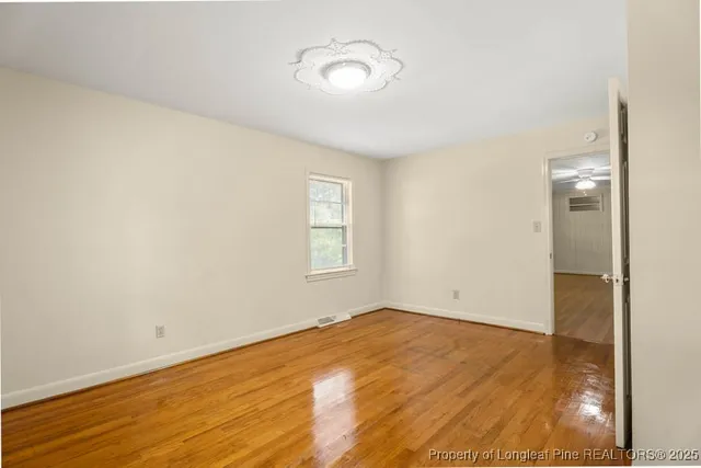 a view of empty room with wooden floor
