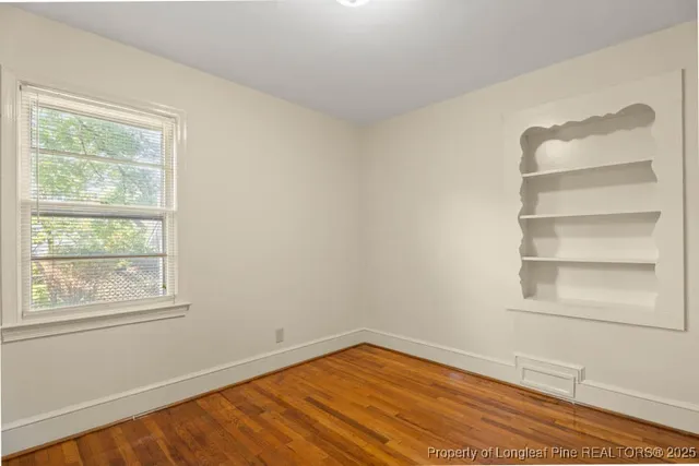 a view of a room with wooden floor and small window