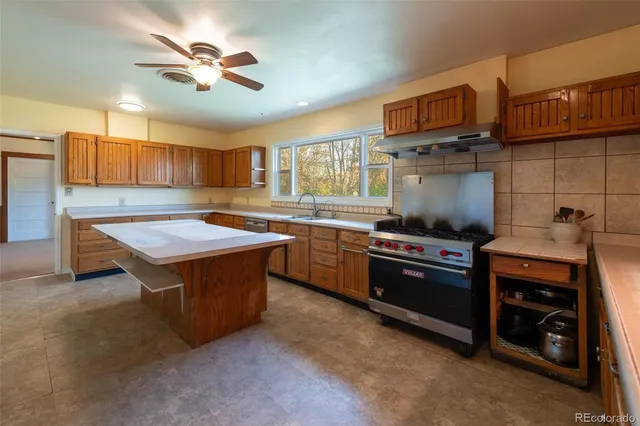 a kitchen with stainless steel appliances granite countertop a stove a sink dishwasher and a refrigerator