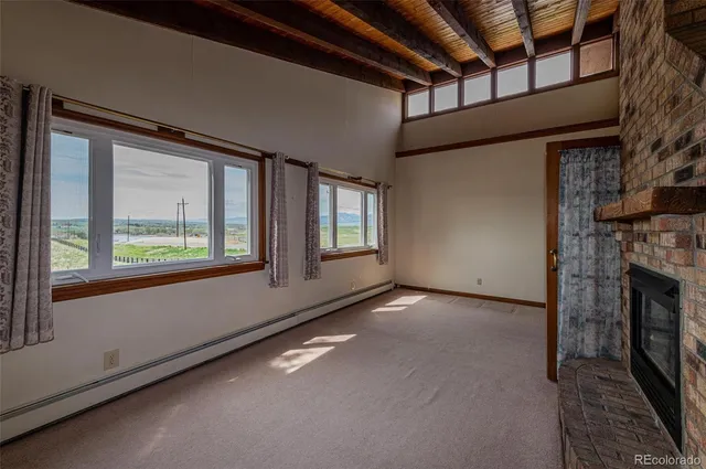 a view of an empty room with a fireplace and a window