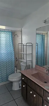a bathroom with a granite countertop toilet sink and mirror