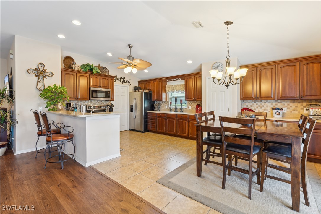 4644 Varsity Circle Lehigh Acres, FL 33971 - Photo 12 of 29 a view of a dining room and livingroom with furniture wooden floor a chandelier
