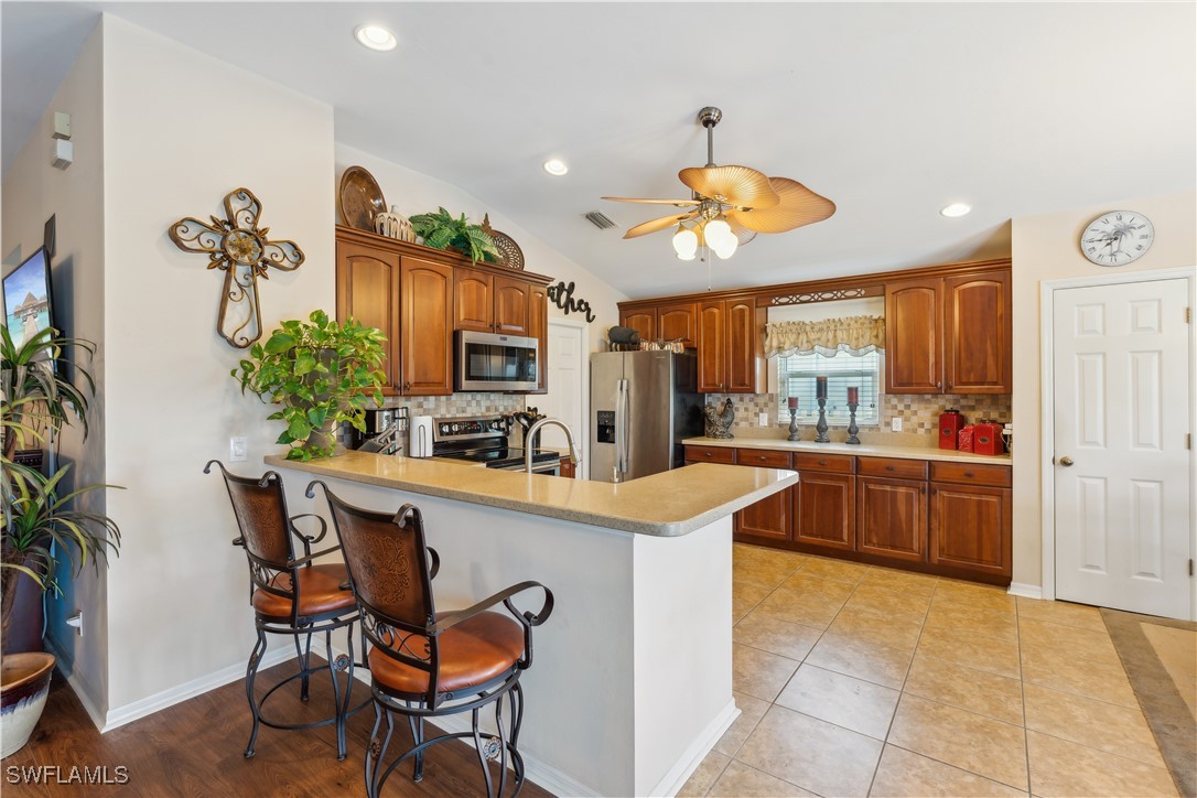4644 Varsity Circle Lehigh Acres, FL 33971 - Photo 9 of 29 a kitchen with stainless steel appliances granite countertop a stove and a refrigerator