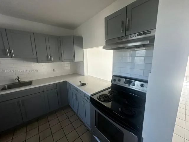 a kitchen with granite countertop a stove and a sink