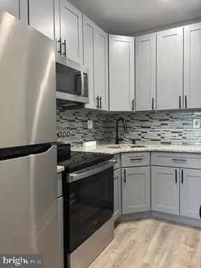 a kitchen with stainless steel appliances granite countertop a stove a refrigerator and a sink