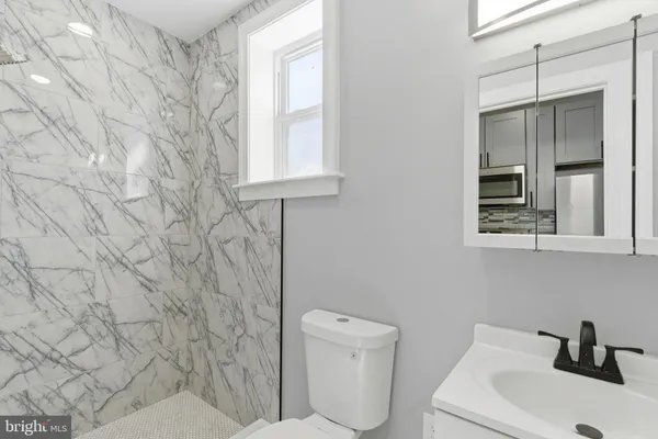 a bathroom with a toilet sink and mirror