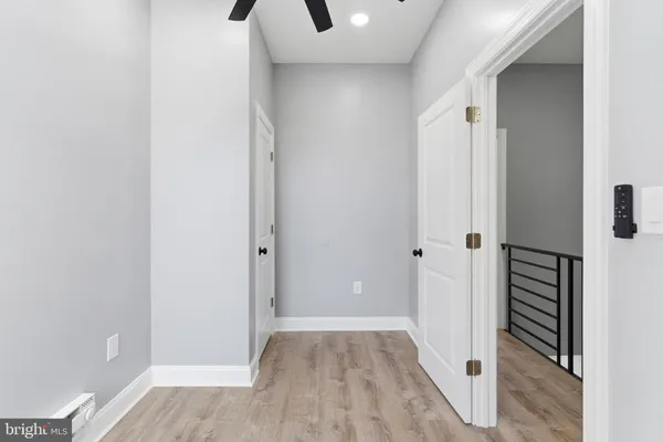 a view of a hallway with wooden floor and closet