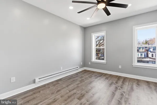 a view of an empty room with a window and wooden floor