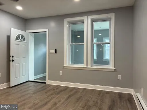 an empty room with window and mirror